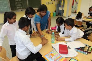 Lehrerin erklärt Schüler*innen aus Sri Lanka eine Aufgabe